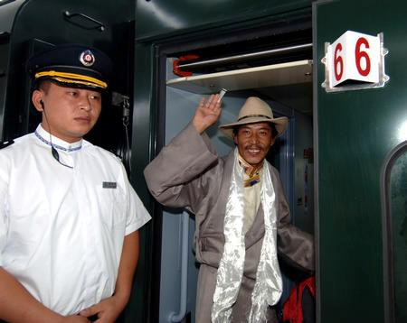 　　△2006年7月1日，第一位检票登车的乘客——来自拉萨柳梧乡的达瓦桑布——登上庆典列车后向站台上的人们挥手。