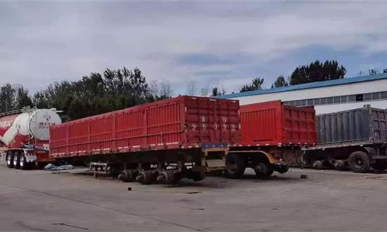 ▷在拳铺镇的改装车院内，三轴挂车的栏板高度明显超标