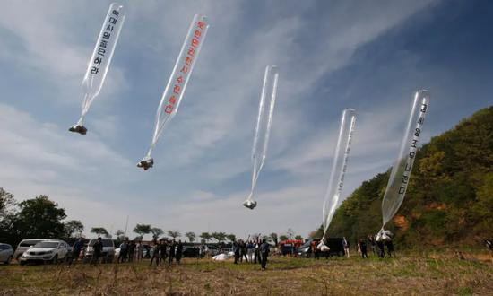  （图说：脱北者用大型气球向朝鲜方向散发传单。图/EPA）