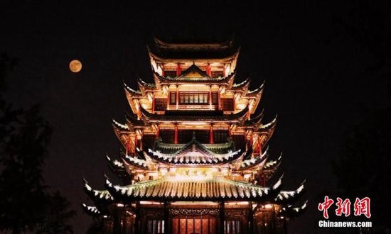  资料图：图为重庆江北区鸿恩阁与中秋明月相映成趣。 殷缘 摄