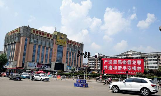 　　在山西省柳林县，陈鸿志控制的燎原大厦是当地的高档商厦，其广场前的扫黑除恶的宣传标语格外醒目。摄影/周群峰