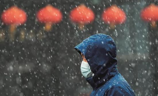 　　2月15日，一名市民在雪中前行。当日，受强冷空气南下影响，武汉气温骤降，午后迎来雨雪天气。图/新华