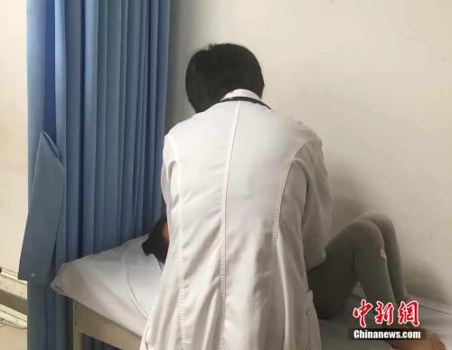 吕芳为患者进行检查。 冷昊阳 摄