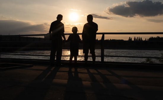 祖孙三代人漫步在夕阳下的黄河岸边