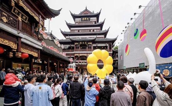上海市民游客在上海豫园商城中心广场观看街头艺术表演（2023年5月7日）。新华社记者刘颖 摄