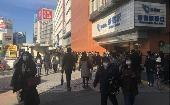 日本东京新宿地铁站口，戴口罩的人们。