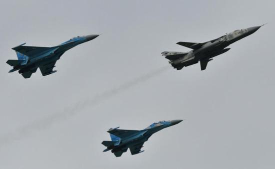  上图为2018 年10月，乌克兰空军举行演习，两架 SU-27 战机护送一架 SU-24 前线轰炸机。