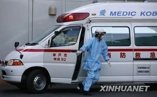  图为2009年5月18日的日本，一名医护人员将患者送抵神户市收治甲型H1N1流感患者的中央市民医院。图源：任正来|新华社