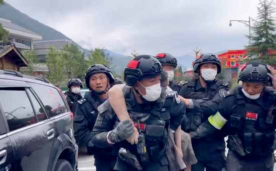 　·陆云涛将伤员背到救援车辆上。来源：封面新闻