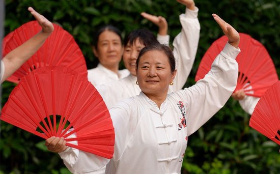  8月8日，太极爱好者在江苏省海安市一住宅小区内练习太极扇。新华社发（周强摄）