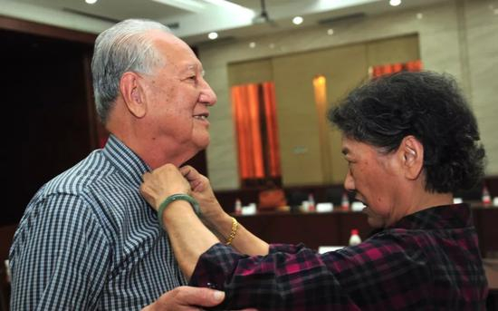 黄旭华夫人李世英（右）在为他整理着装（2014年5月28日）。 　　新华社记者 熊金超 摄