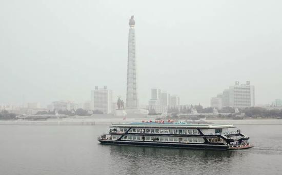 这是2015年10月18日拍摄的从“彩虹”号一层船舷边眺望主体思想塔和大同江上的游船。新华社记者朱龙川摄