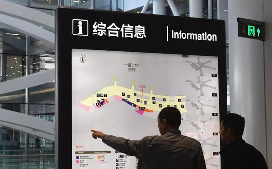 ▲大兴国际机场航站楼一层，两名旅客查看综合信息牌。新京报记者 吴宁&nbsp;摄