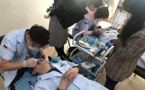  10月25日，经过一天多的培训后，学员们相互进行贴面操作，作为毕业考试内容。新京报记者 刘经宇 摄