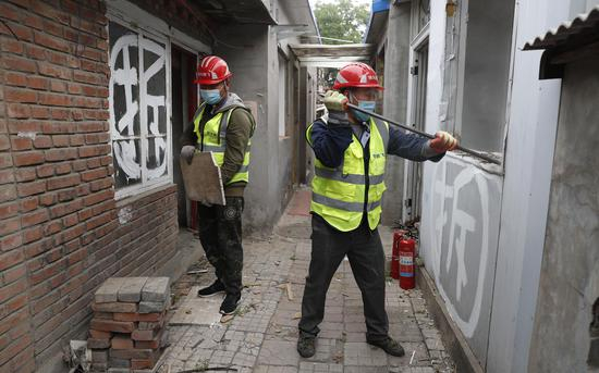 施工工人“纯手工”拆除皇史宬院落内的违建房屋。摄影/新京报记者 侯少卿