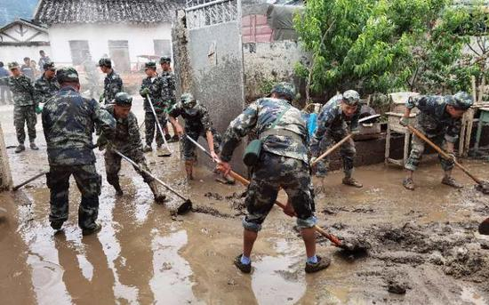洪水过后，救援队帮助村民清理家中淤泥。受访者供图