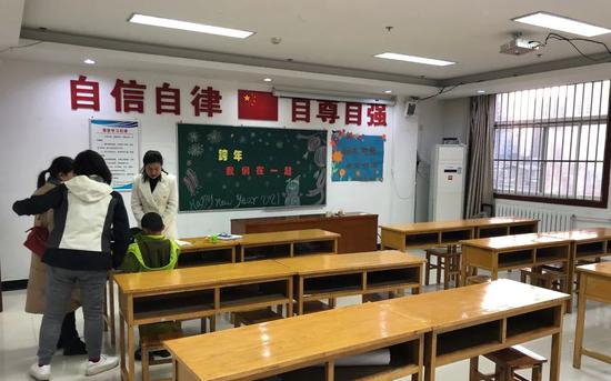 ▲2020年12月30日，渭南未保中心社工在检查孩子的作业。新京报记者 韩沁珂 摄