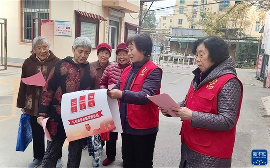 　　11月29日，山东省济宁市任城区济阳街道楼长给居民宣传人大换届选举有关知识。新华社发（孙艳 摄）