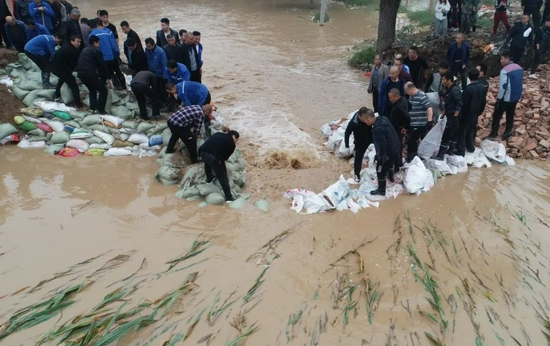 10月7日，山西省运城市稷山县稷峰镇西薛村，民众合力抗洪，封堵西坝决口。