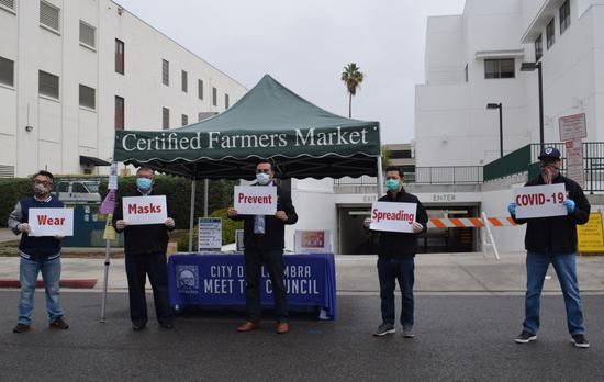 4月5日，在美国洛杉矶农夫市场，阿尔汉布拉市前市长沈时康（左二）与现任市长罗斯·马扎（左三）宣传新冠防疫知识并免费分发当地华侨华人捐赠的口罩。（新华社发）
