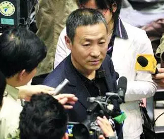 图为许霆父亲进入法庭即被传媒追访。