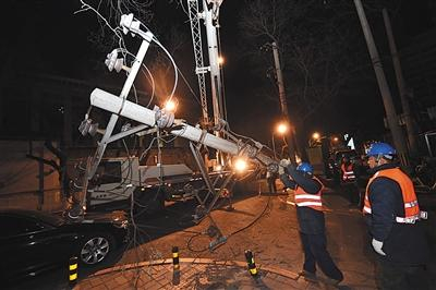 12月20日凌晨，东城区正义路，电力公司人员正在拆除电线杆。 新京报记者 陶冉 摄
