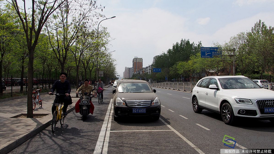  2017年4月14日，北京市石景山苹果园南路出现了一种新式路侧停车位，位置从紧贴便道旁边挪到了机动车道和非机动车道中间。这样的停车位在全市还属首创，目的是为了解决停车难的同时保障非机动车的路权（图片来源：tuku.qianlong.com）。杜建坡摄 千龙网发