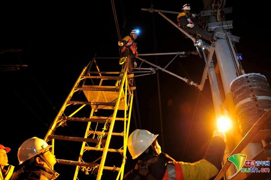  因为高度较高，同事使用大绳向在高空检修的刘帅传递工具。中国青年网记者　刘尚君摄