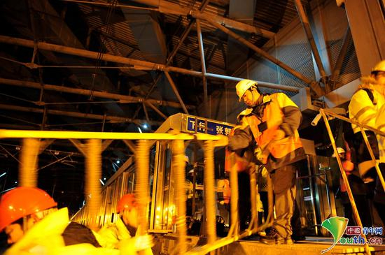 深夜，地铁末班车返回场段，夜间的检修工作才刚刚开始。刘帅和同事搬运工具进入轨行区，准备开始检修。中国青年网记者　刘尚君摄