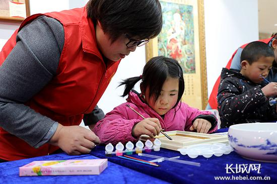 小朋友们在工作人员的指导下，完成作品。记者 高琳哲 摄