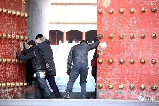 一个在里面开锁，两到三个人在外面往里边推