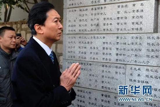鸠山由纪夫双手合十参观刻有一万多遇难者名单的“哭墙” | 新华社 韩瑜庆 摄