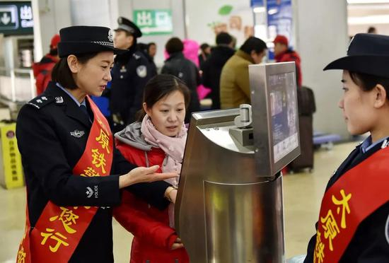 2月1日，太原火车站派出所民警孟佳（前左）使用人脸识别系统对进站旅客进行“刷脸”识别。&nbsp;&nbsp; &nbsp; 新华社记者 曹阳 摄
