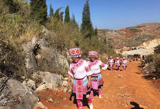 ▷穿着民族服装前往花场的村民