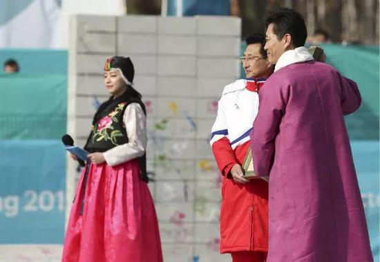 2月8日，江陵运动员村村长金琪勋（右）与朝鲜体育代表团团长元吉宇交换礼物。新华社记者韩岩摄