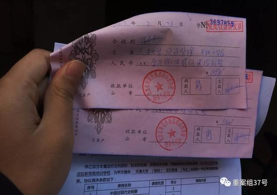 ▲12月21日，建外派出所门口，一名新丝路学员给记者观看他的两张收据和合同。&nbsp;&nbsp;&nbsp;&nbsp;新京报记者 大路 摄