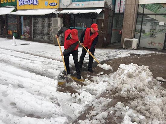 合肥海棠社区工作人员走上街头铲雪。