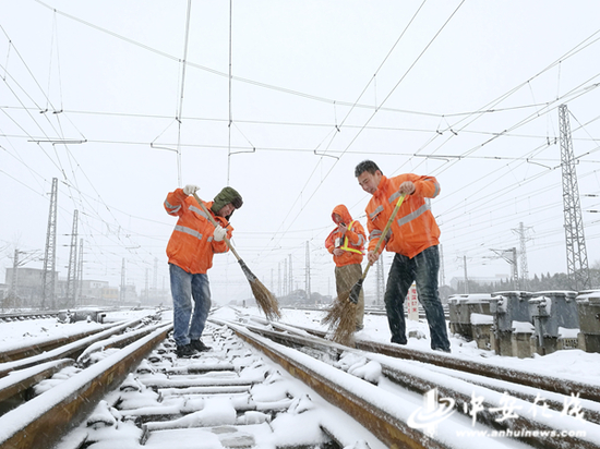 中国铁路上海局集团有限公司合肥电务段职工在阜阳北站扫雪。（刘辉摄）