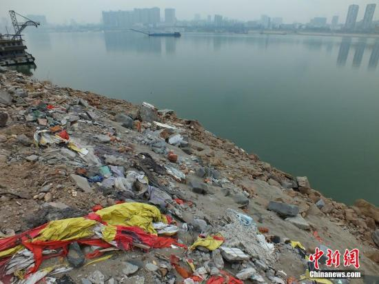 资料图：长江河道边堆积渣土垃圾成山。