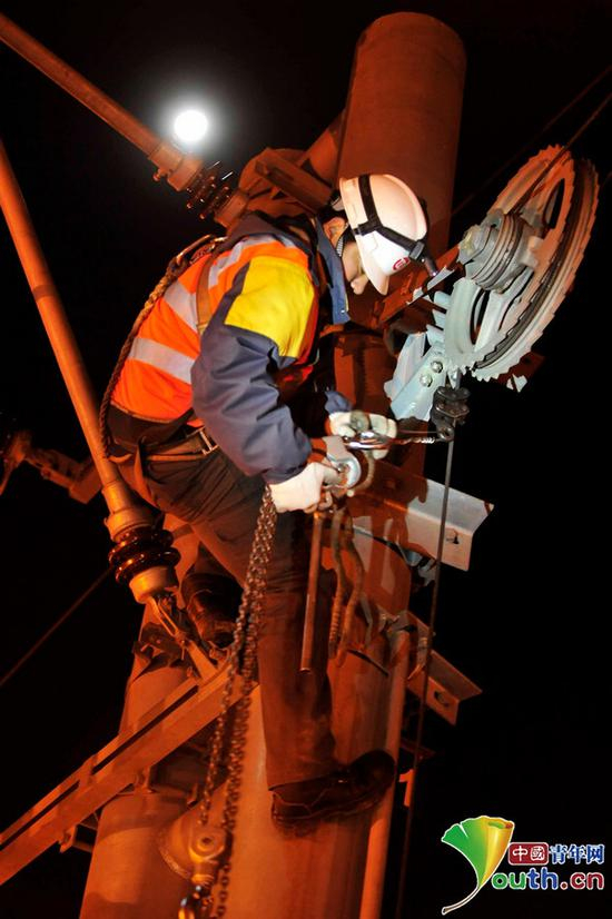 刘帅使用检修专用工具——手扳葫芦对重达400公斤的坠砣进行调整。中国青年网记者　刘尚君摄