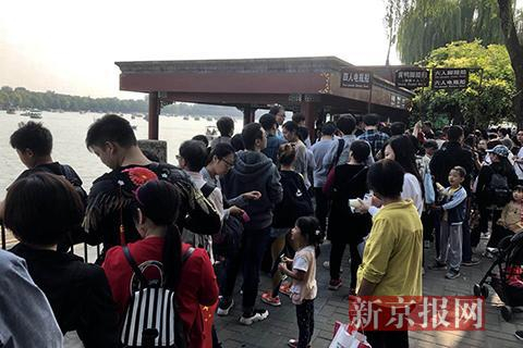 游客们在排队买船票。