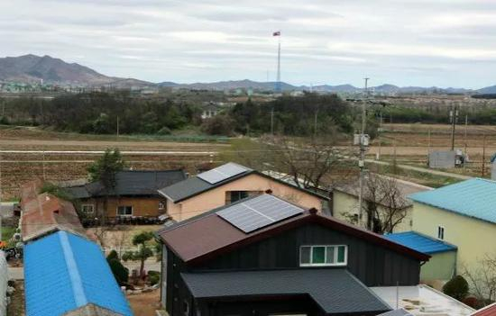 这是4月24日拍摄的韩国大成洞村一角，远处的朝鲜国旗清晰可见。 新华社记者李鹏摄