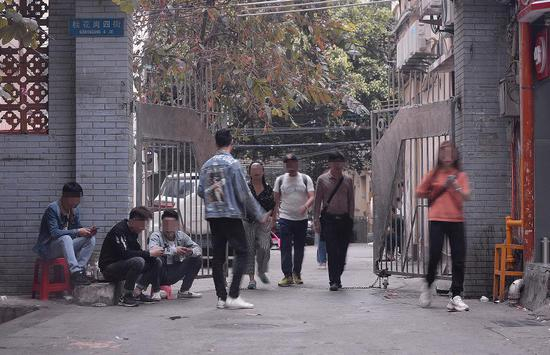 　　3月16日下午，广州市白云世界皮具贸易中心旁桂花岗小区。记者连续多日观察后发现，该小区的几个入口和内部，长期有拉客人员和望风看场子的人员聚集。 &nbsp;&nbsp; 新京报记者 吴江 摄