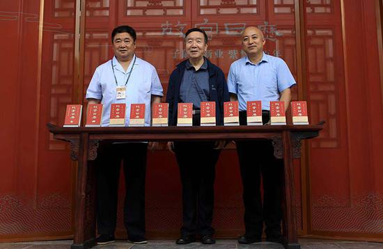 三任故宫院长（左至右：单霁翔，郑欣淼，现任院长王旭东）在历年的《故宫日历》前留影。《故宫日历》已累计发行300万册。