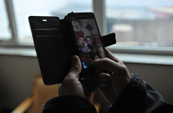 　　2月3日，农历腊月二十九。李玉宝的手机里存着一张全家福。今年春节，儿子带着妻儿去东北老丈人家过年，家里就剩下李玉宝老两口。&nbsp;&nbsp;&nbsp;&nbsp;新京报记者 吴江 摄