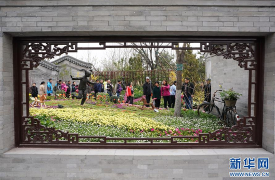 　4月20日，参观者在北京园内游览。4月20日，北京世园会园区进行全负荷压力测试。6万多名参观者进入园区，园区按正式开园标准组织开展运营工作，完成了全员、全范围的实战演练，以检验园区、外围交通及属地保障全负荷运营能力。　新华社记者 鞠焕宗 摄