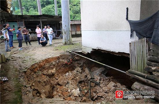 居民楼墙角地陷，形成一个大坑。 南国早报 图