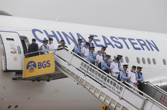 　　6月7日7时许，一架中国民航包机降落在首都国际机场，94名台湾籍电信网络诈骗嫌疑人被民警从西班牙押解回国。新京报记者 王贵彬 摄