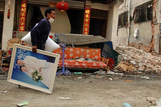 2008年5月23日，四川绵阳市陈家坝，一受灾群众回乡取走结婚照。
