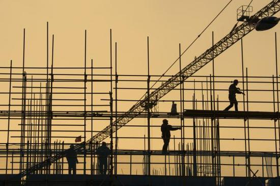 2019年1月1日，在江苏省海安市一建筑工地，工人在脚手架上作业。新华社 图